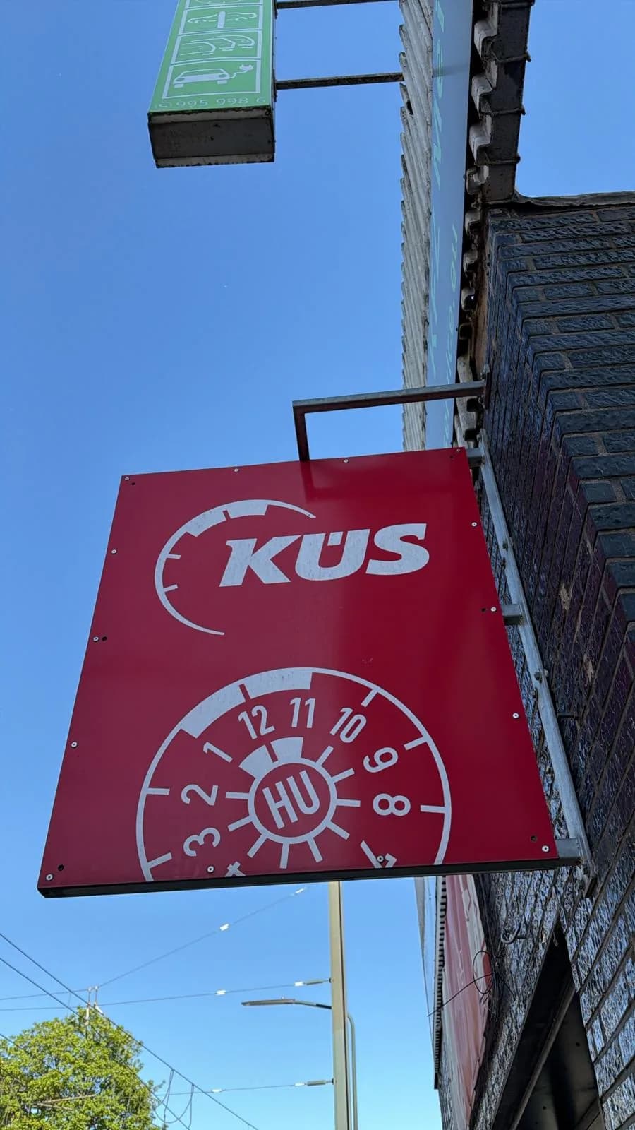 KÜS-Prüfstellen-Schild an der Fassade von PK Service in Düsseldorf-Benrath